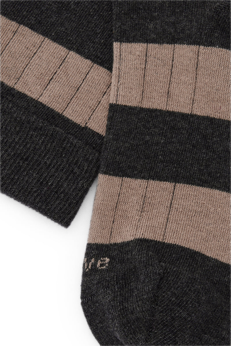 Calcetines mid-calf con rayas anchas en marrón y gris oscuro, mezcla de algodón, poliamida y lycra; detalle de logo bordado y fabricación española.