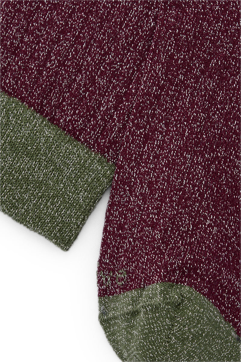 Calcetines mid-calf color borgoña con brillo de lurex gris, mezcla de algodón, poliamida y lycra; detalle de logo bordado, fabricación española.