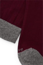 Calcetines mid-calf color burdeos con tejido canalé, mezcla de algodón y lycra, detalle NAIVE en la punta; fabricación española.