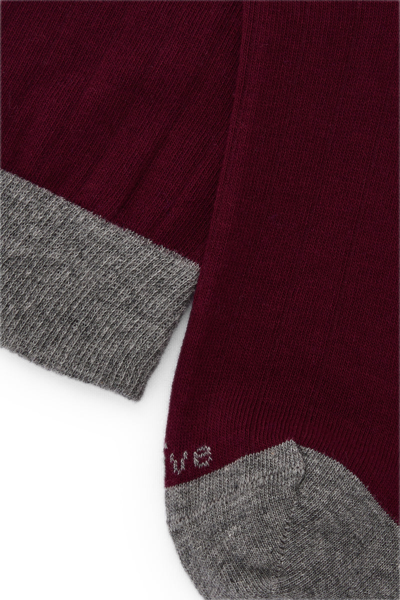 Calcetines mid-calf color burdeos con tejido canalé, mezcla de algodón y lycra, detalle NAIVE en la punta; fabricación española.