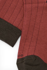 Calcetines knee-high color caldero (burnt orange) con tejido canalé; mezcla de algodón, poliamida y lycra; detalle de logo bordado; fabricación española.