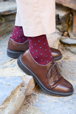 Calcetines premium burdeos con puntitos azul cielo, caña alta, 90 % algodón y detalle de logo; hechos artesanalmente en España.