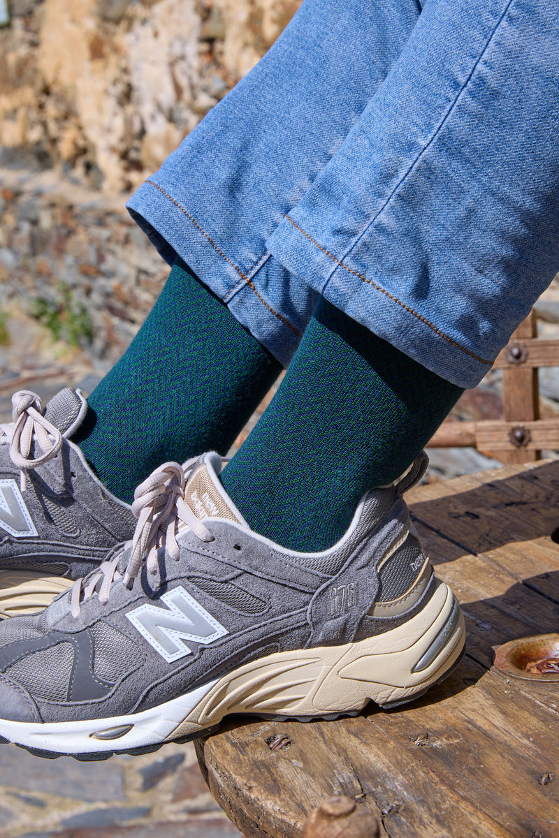 Calcetines de fondo azul con tejido de espiga, caña media, 90 % algodón y logo bordado; hechos en España.
