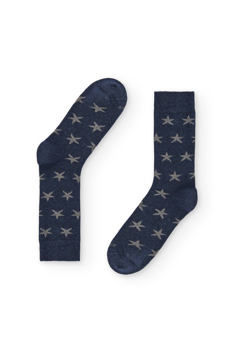 Calcetines azul marino de caña media con estrellas grises, 90 % algodón y logo NAIVE en la puntera; tejidos en España.