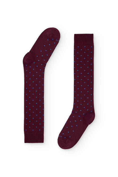 Calcetines burdeos de caña alta con puntitos azul claro, 100 % algodón y logo NAIVE en la puntera; tejidos en España.

