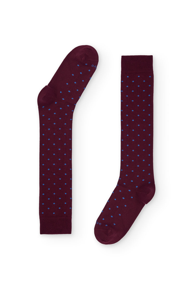Calcetines burdeos de caña alta con puntitos azul claro, 100 % algodón y logo NAIVE en la puntera; tejidos en España.

