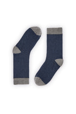 Calcetines azul oscuro de canalé, caña alta, 90 % algodón y logo en la puntera; tejidos en España.