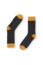 Calcetines gris oscuro de canalé, caña alta, 90 % algodón y logo NAIVE en la puntera; tejidos en España.