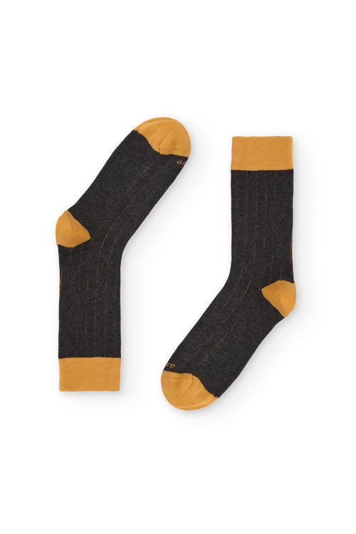 Calcetines gris oscuro de canalé, caña alta, 90 % algodón y logo NAIVE en la puntera; tejidos en España.