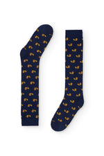 Calcetines azul oscuro con estampado de patitos, caña alta, 90 % algodón y logo NAIVE en la puntera; tejidos en España.