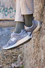 Calcetines de fondo gris con tejido espiga, caña media, 90 % algodón y logo bordado; hechos en España.