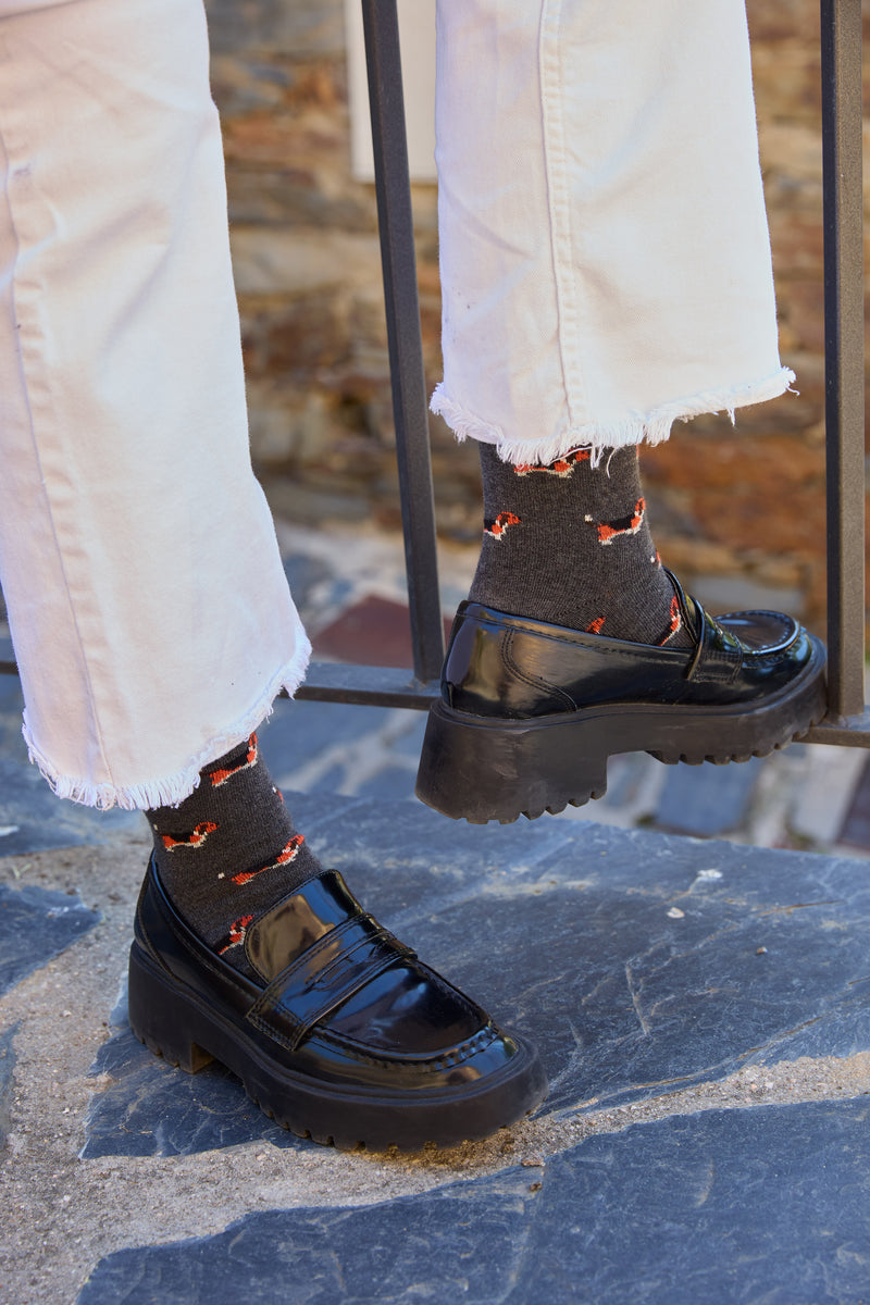 Calcetines de fondo gris oscuro con motivo beagle, caña alta, 90 % algodón, logo bordado en la punta; hechos en España.