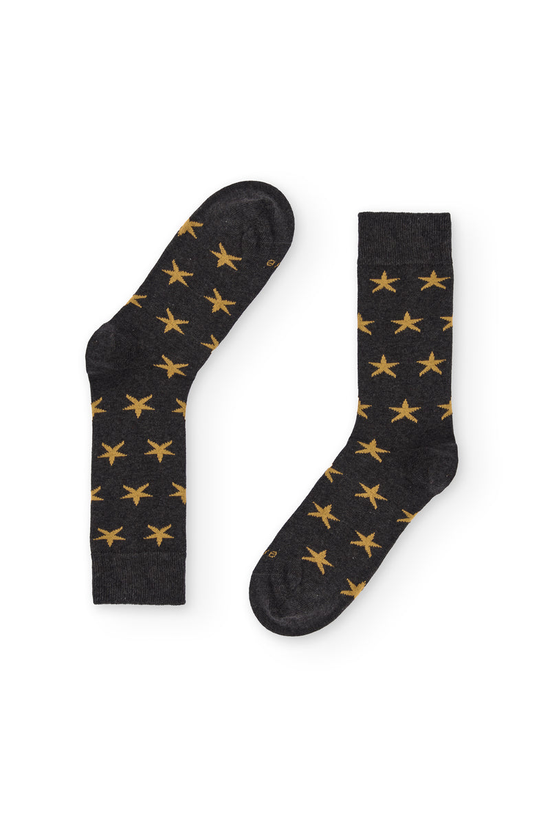 Calcetines de caña media con estampado de estrellas, 90 % algodón y logo NAIVE en la puntera; tejidos en España.