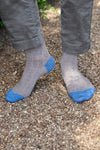 Calcetines lisos grises de canalé, caña media, 90 % algodón y logo bordado; hechos artesanalmente en España.