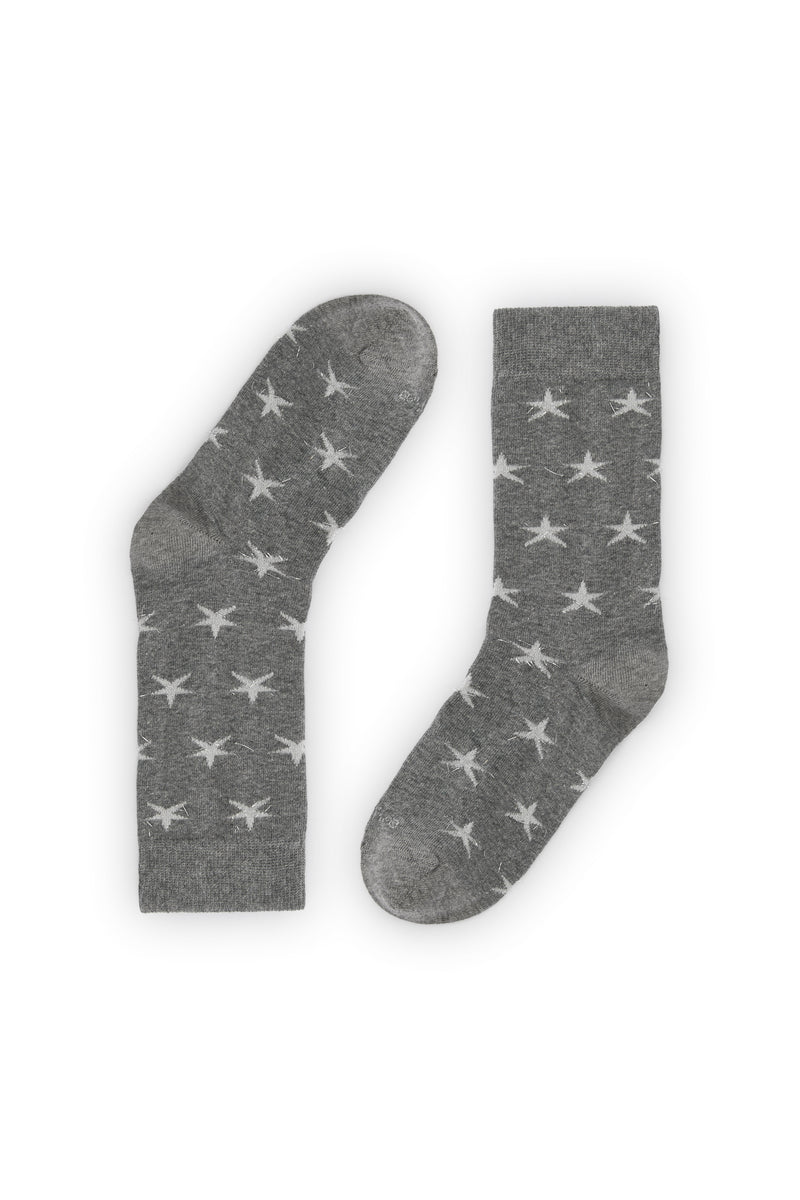 Calcetines gris medio con estrellas en hilo metalizado, media caña, 90 % algodón y logo NAIVE en la puntera; tejidos en España.