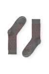Calcetines gris medio de caña alta con estrellitas rojas, 90 % algodón y logo NAIVE en la puntera; tejidos en España.