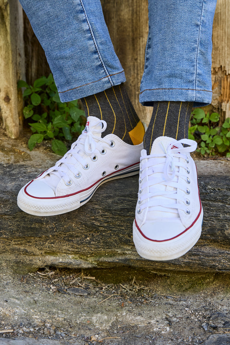 Calcetines gris carbón de canalé, caña alta y logo bordado; 90 % algodón, hechos artesanalmente en España.