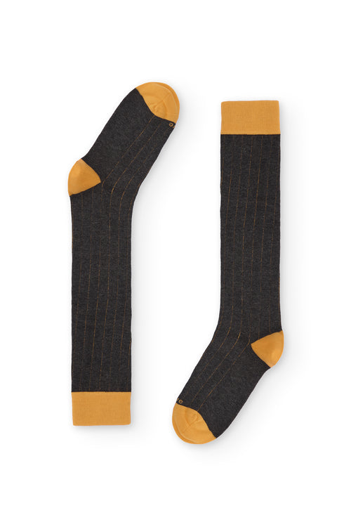 Calcetines de canalé gris oscuro, caña alta, 90 % algodón y logo NAIVE en la puntera; tejidos en España.
