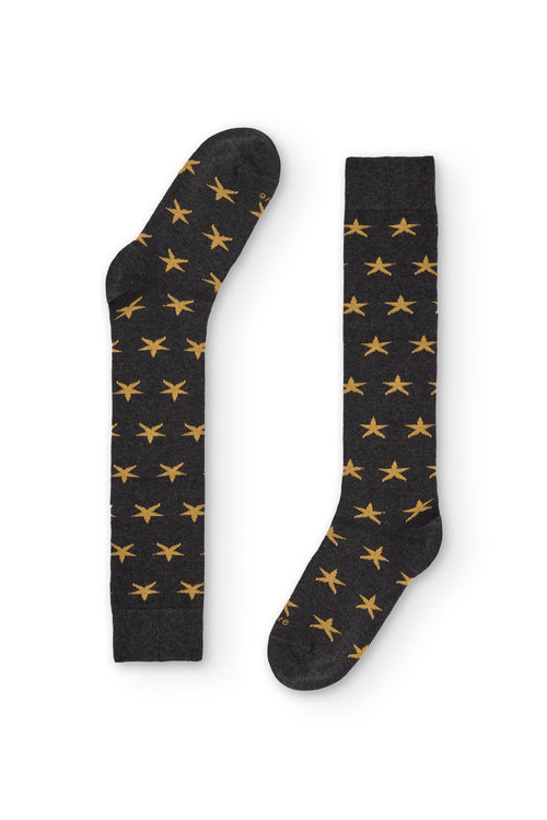 Calcetines gris oscuro de caña alta con estrellas amarillas, 90 % algodón y logo NAIVE en la puntera; tejidos en España.
