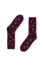 Calcetines burdeos con estampado de huellas, caña media, 90 % algodón y logo en la puntera, tejidos en España.