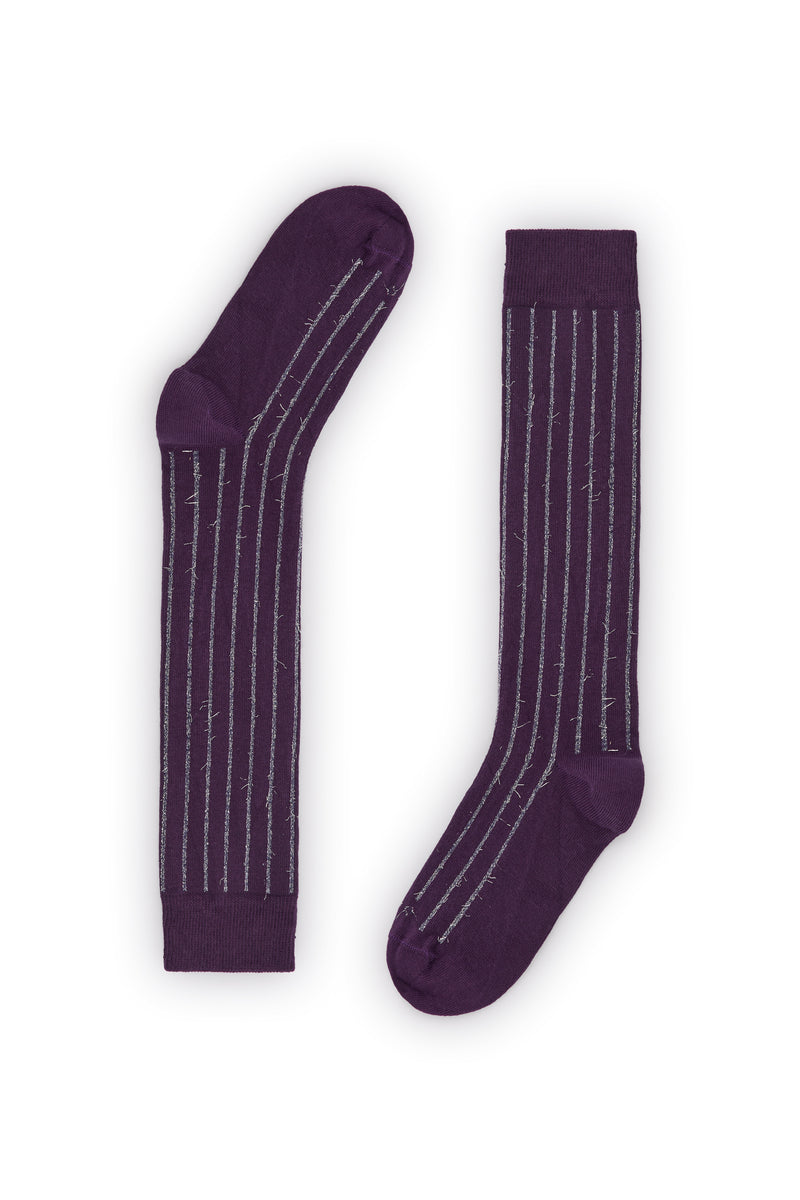 Calcetines púrpura de canalé, caña alta, con hilo metalizado gris, 90 % algodón y logo NAIVE en la puntera, tejidos en España.