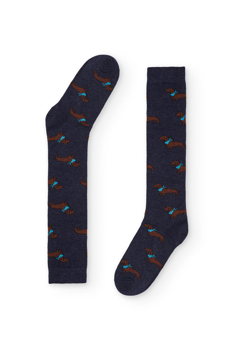 Calcetines azul oscuro con estampado de teckel, caña alta, 90 % algodón y logo NAIVE en la puntera; tejidos en España.