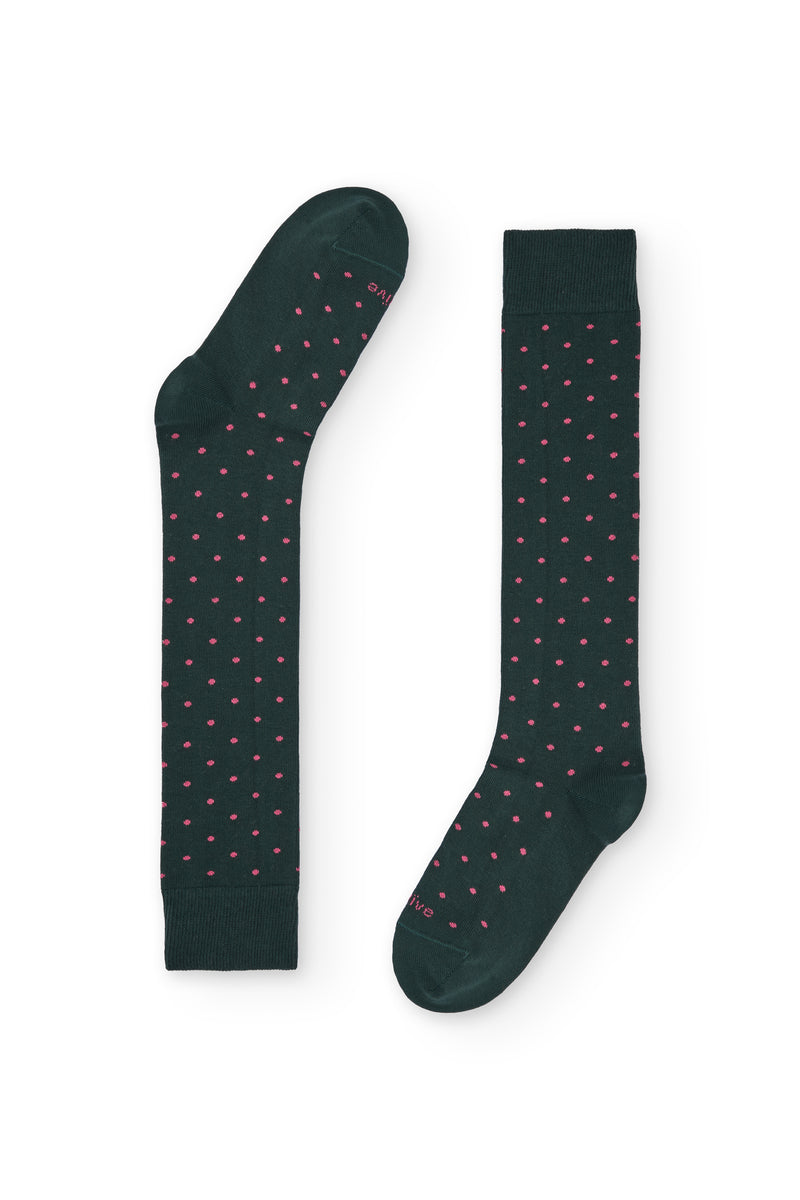 Calcetines verdes de caña alta con puntitos rosados, 90 % algodón y logo NAIVE en la puntera; tejidos en España.