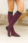 Calcetines de fondo verde con patrón espiga rosa, caña alta, 90 % algodón y logo bordado; hechos en España.