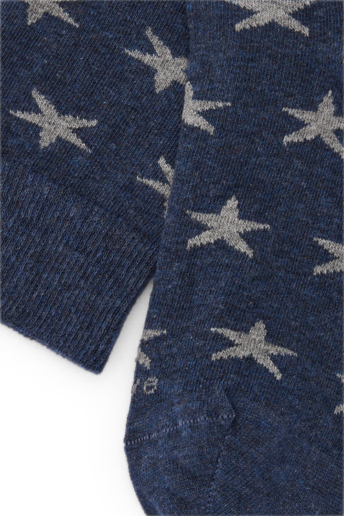 Calcetines knee-high azul oscuro con motivo de estrellas tono sobre tono en azul, mezcla de algodón, poliamida y lycra; logo bordado y fabricación española.