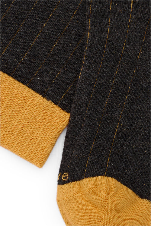 Calcetines knee-high gris oscuro con tejido canalé, mezcla de algodón y lycra, detalle de logo bordado; fabricación española.