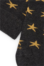 Calcetines knee-high gris oscuro con estampado de estrellas amarillas, mezcla de algodón, poliamida y lycra; logo bordado y fabricación española.