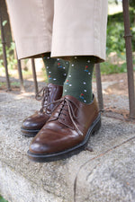 Calcetines verdes con temática de golf, tejido transpirable de algodón y poliamida, caña media y detalle de logo NAIVE, producción española.