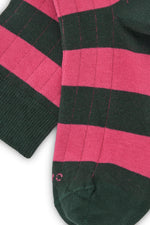 Calcetines knee-high con franjas anchas verde oscuro y rosa, mezcla de algodón, poliamida y lycra; detalle de logo bordado y fabricación española.