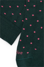Calcetines knee-high color verde con lunares rosados, mezcla de algodón, poliamida y lycra; logo bordado y fabricación española.