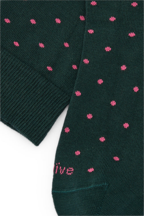 Calcetines mid-calf color verde con estampado de lunares rosados, mezcla de algodón, poliamida y lycra; logo bordado y fabricación española.