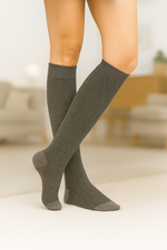 Calcetines gris de caña larga con diseño espiga, algodón suave y logo en la puntera; confeccionados artesanalmente en España.