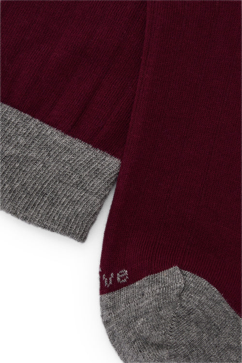 Calcetines knee-high color burdeos, diseño liso, mezcla de algodón y lycra, detalle NAIVE en la punta; fabricación española.