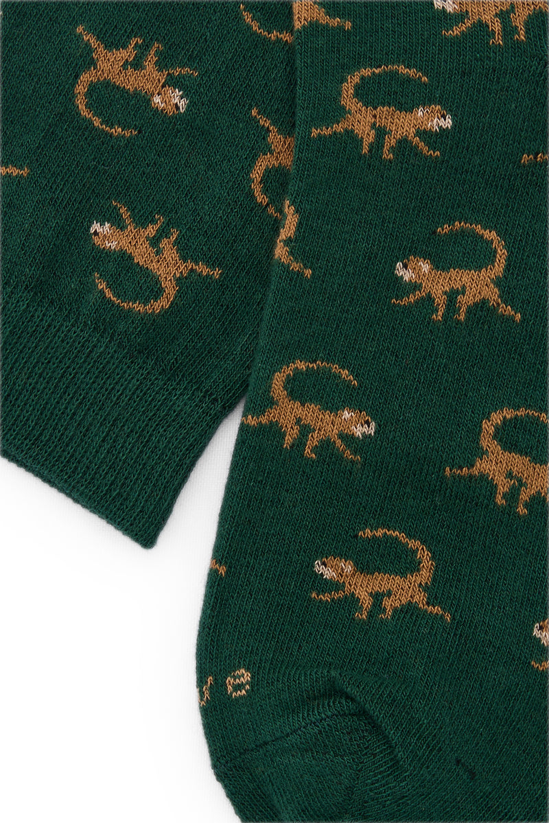 Calcetines mid-calf verde con diseño de monos, mezcla de algodón y lycra, detalle de logo, fabricación española.