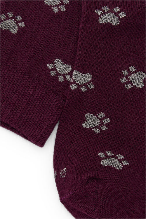 Calcetines knee-high burdeos con diseño de huellas, mezcla de algodón, poliamida y lycra; detalle de logo y fabricación española.
