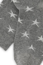 Calcetines mid-calf gris con estampado de estrellas y brillo lurex, mezcla de algodón, poliamida y lycra; detalle de logo bordado y fabricación española.