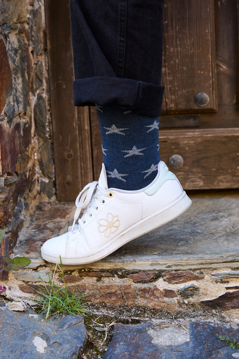 Calcetines NAIVE azules con motivo de estrellas grises, tejido transpirable de algodón y lycra, caña media y logo en la puntera; producción española.