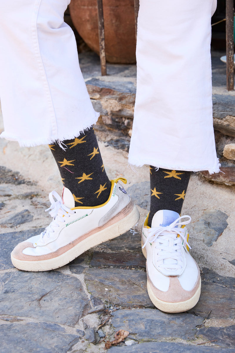 Calcetines NAIVE caña alta gris oscuro con motivo de estrellas amarillas, tejido transpirable de algodón y lycra, logo en la puntera; producción española.